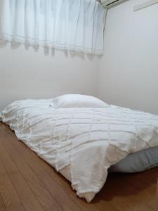 a white bed in a bedroom with a window at Tokyo downtown in Tokyo