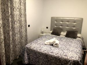 Un dormitorio con una cama con una toalla blanca. en Alojamientos Marel Sanabria, en Villarino de Sanabria