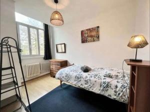 een slaapkamer met een bed, een lamp en een ladder bij Domaine Les Tourelles 3 in Caffiers