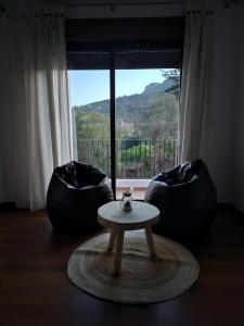 a room with two chairs and a table and a window at Ca Vicent in Estivella