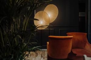 Pokój z 2 pomarańczowymi krzesłami i lampą w obiekcie Maison Urbaine w Paryżu