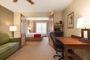 a hotel room with a desk and a bed at Country Inn & Suites by Radisson, Davenport, IA in Davenport