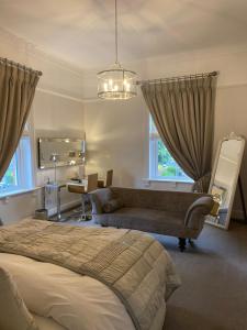 a bedroom with a bed and a chair and a mirror at Alexandra Court Hotel in Congleton