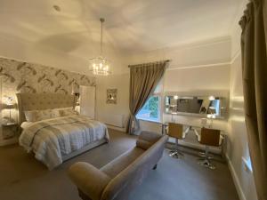 a bedroom with a bed and a couch and a chair at Alexandra Court Hotel in Congleton