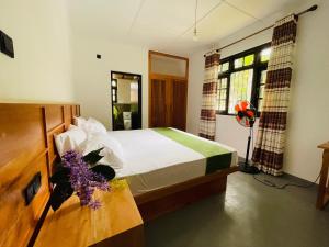 a bedroom with a bed and a table with flowers on it at 1818 Badulla in Badulla