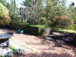 eine Terrasse mit Stühlen und einem Tisch im Garten in der Unterkunft Hobreid Park in Woodend