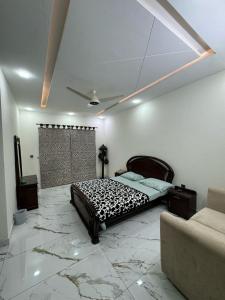 a bedroom with a bed in a room with marble floors at AAS HOSTS in Islamabad
