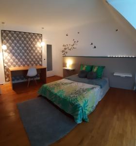 1 dormitorio con cama, escritorio y escalera en Chambre-Suite (SDB & Cuisinette) centre historique Bourges, en Bourges