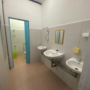 a bathroom with two sinks and a mirror at Beautiful River Homestay Kuala Pontian Rompin in Kuala Rompin