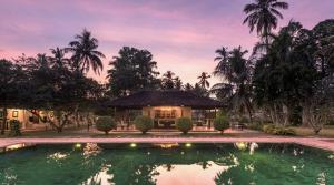 a villa with a pool in front of a house at Uga Riva - Negombo in Negombo