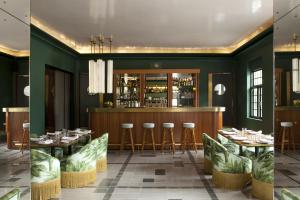 two views of a restaurant with green walls and a bar at Casa Habita, a Member of Design Hotels in Guadalajara