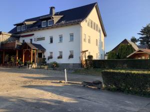 a large white house with a black roof at Pension Scherzer in Ohorn