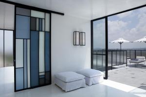 a white living room with a couch and windows at Casa Habita, a Member of Design Hotels in Guadalajara