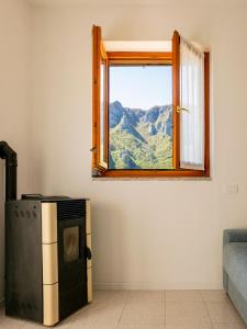a window with a view of a mountain at La Betulla - vicino al lago, vicino alle montagne in Ballabio