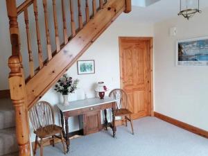a room with a desk with two chairs and a staircase at Stunning Detached 3 Bedroom House Islandandmagee in Larne