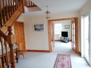 a hallway with a staircase and a living room at Stunning Detached 3 Bedroom House Islandandmagee in Larne