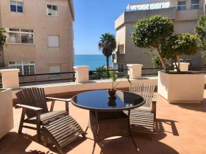 un patio con mesa, sillas y el océano en Siriana Suites 101, 001, en Benalmádena