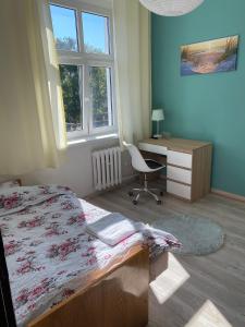 a bedroom with a bed and a desk and a chair at Magnolia 2 in Toruń