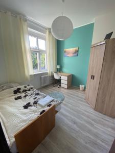 a bedroom with a bed and a desk and a window at Magnolia 2 in Toruń