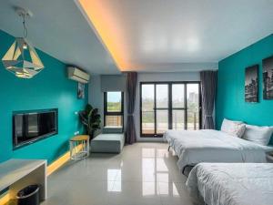 a hotel room with two beds and a tv at Silimu Hostel in Toucheng