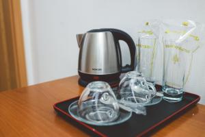 a coffee maker and glasses on a tray on a table at AMMOTTI Hotel and Apartments in Ohrid