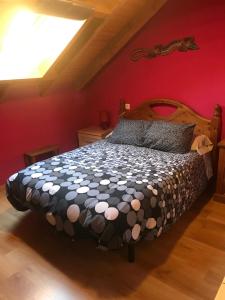 a bedroom with a large bed in a red wall at Alojamientos Casa San Habitaciónes in Besande