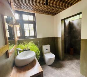 a bathroom with a white toilet and a sink at 1818 Badulla in Badulla