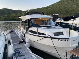 a white boat docked at a dock in the water at Koolhouse Boat in Vila Nova de Foz Coa
