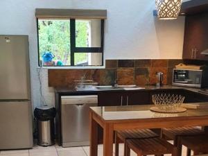 uma cozinha com uma mesa, um lavatório e uma janela em Marloth Cottage em Marloth Park