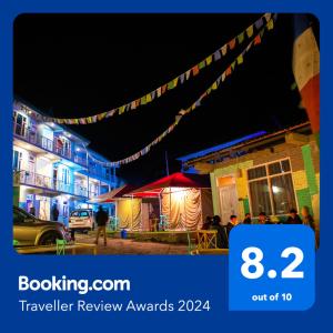 a sign that says travel review awards at night at Zostel Chitkul in Chitkul