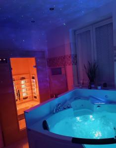 a large bath tub in a bathroom with purple lighting at Apartmán s privátnym wellnessom Exwell in Trenčín
