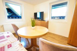 een kleine kamer met een tafel en twee ramen bij Apartments Pr' Pavleto in Bohinj
