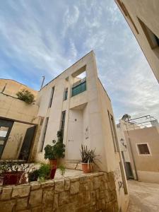 un edificio blanco con una puerta y algunas plantas en LovelyLoft La Ereta, en Alicante