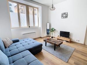 a living room with a blue couch and a table at Le cèdre de Jori in Voiron