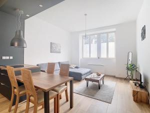 a living room with a table and a couch at Le cèdre de Jori in Voiron