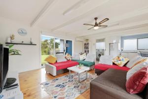 a living room with two couches and a tv at Quiet Holiday Home in Surf Beach VIC in Surf Beach