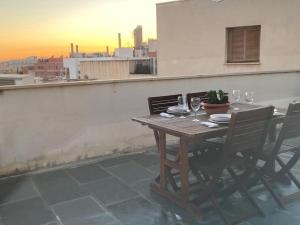una mesa de madera con sillas y copas de vino en el balcón en LovelyLoft La Ereta, en Alicante