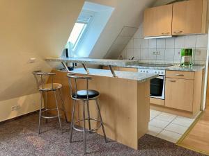 a kitchen with a counter and two stools in it at Star Camp Cosa, Ferienwohnungen, Camping, Schlaffässer in Friedland