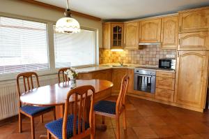 een keuken met een houten tafel en een tafel met stoelen bij Apartments Pr' Pavleto in Bohinj