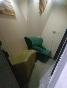 a bathroom with a green couch and a green chair at Corner House in Dubai