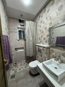 a bathroom with a white toilet and a sink at AAS HOSTS in Islamabad