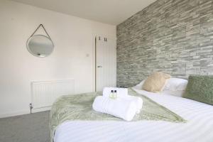 a bedroom with a bed with two towels on it at StayRight 2 Bed House - Quick Drive to Brecon Beacons & more in Griffithstown