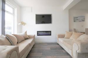 a living room with a couch and a fireplace at StayRight 2 Bed House - Quick Drive to Brecon Beacons & more in Griffithstown