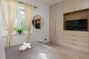 a bedroom with a bed and a tv and a mirror at Luxury Apartments Blue Moon - New Apartments in Slano