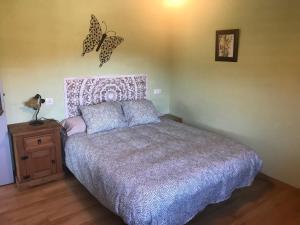 a bedroom with a bed with butterflies on the wall at Alojamientos Casa San Habitaciónes in Besande