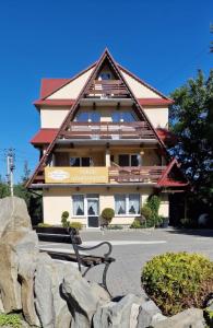 un edificio con un banco delante de él en Bukowiański Dworek, en Bukowina Tatrzańska