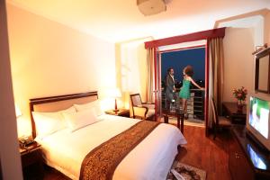 ein Hotelzimmer mit einem Bett und einem Mann und einer Frau in der Unterkunft Wassamar Hotel in Addis Abeba