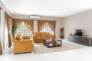 sala de estar con 2 sillas y TV en LA CASA BORNEO, en Bentakan Kecil