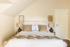 a bedroom with a large white bed with two lamps at Beautiful large luxury home in London in Sidcup