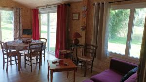 a living room with a table and chairs and a couch at GITE LES ECUREUILS in Fresse